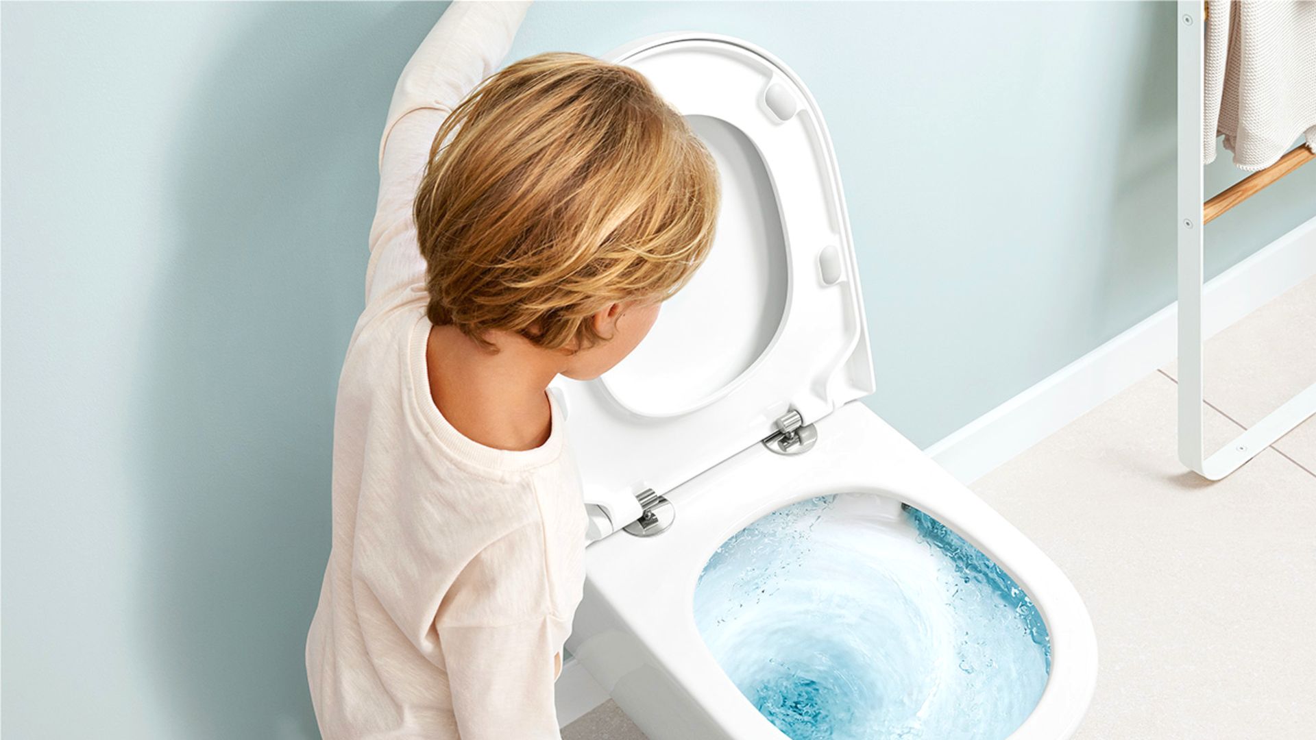 Child Flushing Toilet In Bathroom