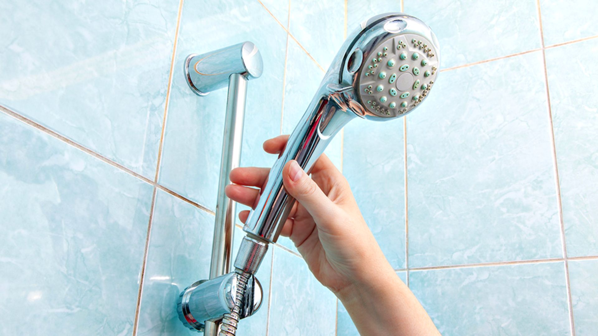 Person Removing Shower Head
